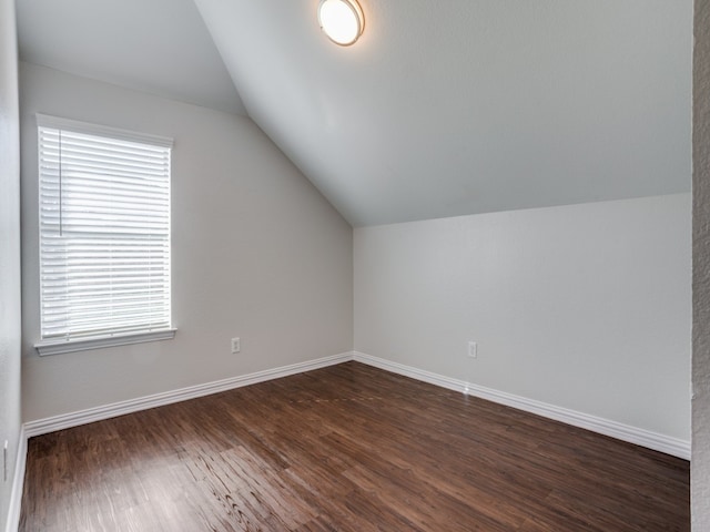 additional living space with dark hardwood / wood-style flooring and lofted ceiling