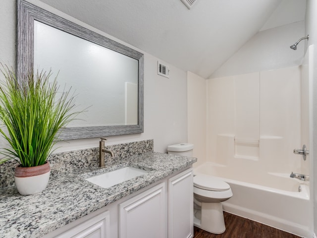 full bathroom featuring vanity, bathing tub / shower combination, hardwood / wood-style flooring, toilet, and lofted ceiling