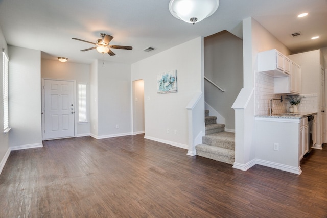 unfurnished living room featuring ceiling fan, dark hardwood / wood-style flooring, and sink