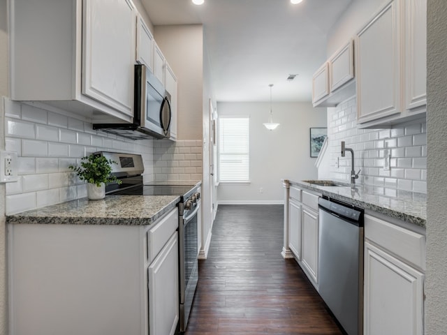 kitchen with appliances with stainless steel finishes, white cabinetry, pendant lighting, and sink