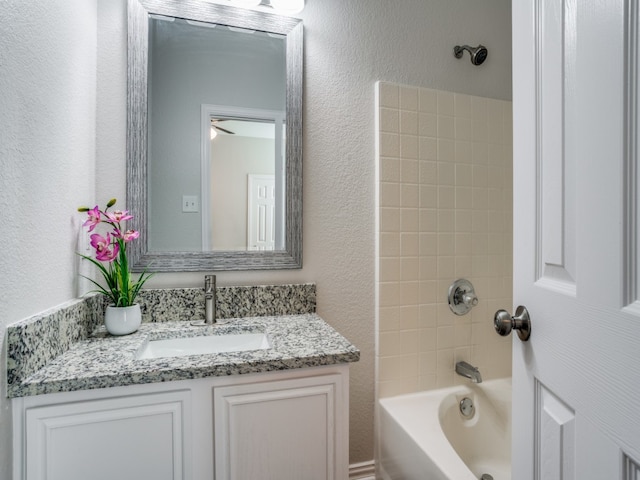 bathroom featuring vanity, tiled shower / bath, and ceiling fan