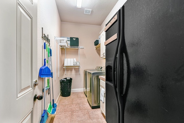 washroom featuring light tile patterned floors, washing machine and dryer, and a textured ceiling