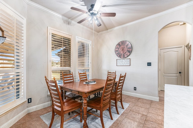 tiled dining area featuring ornamental molding and ceiling fan