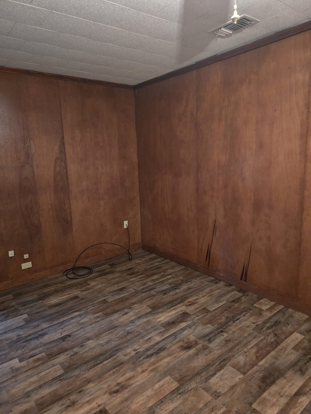 unfurnished room with dark hardwood / wood-style flooring and wood walls