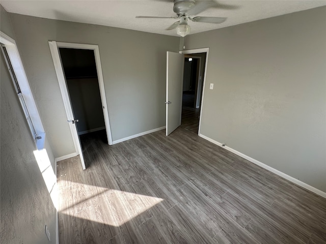 unfurnished bedroom with hardwood / wood-style flooring, ceiling fan, a spacious closet, and a closet