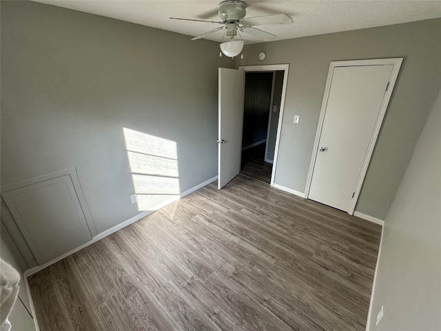 unfurnished room with ceiling fan, a textured ceiling, and hardwood / wood-style flooring