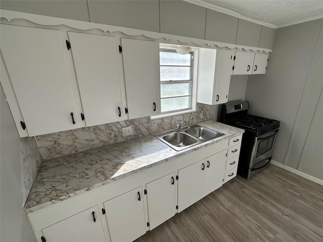 424 E Ragley St, Henderson, TX 75654 - kitchen featuring gas stove, a sink, ornamental molding, white cabinetry, and light countertops