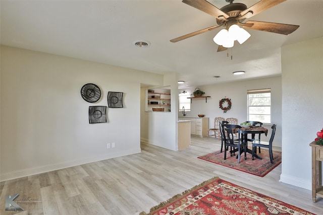 dining space with ceiling fan, sink, and light hardwood / wood-style floors