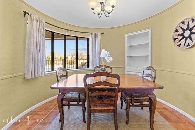 dining room featuring tile patterned floors, built in features, and a chandelier