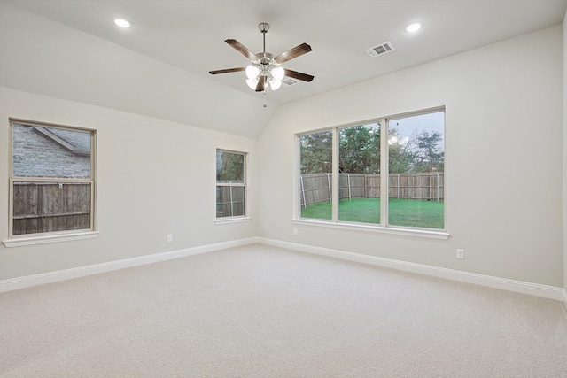 carpeted spare room featuring ceiling fan and lofted ceiling