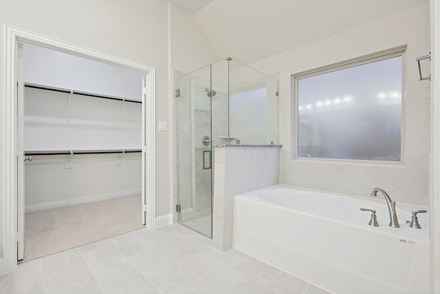 bathroom with tile patterned flooring, vaulted ceiling, and shower with separate bathtub