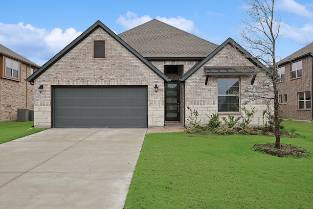 view of front of home with central air condition unit, a front yard, and a garage