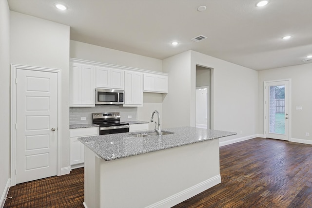 kitchen featuring white cabinets, a kitchen island with sink, sink, and appliances with stainless steel finishes