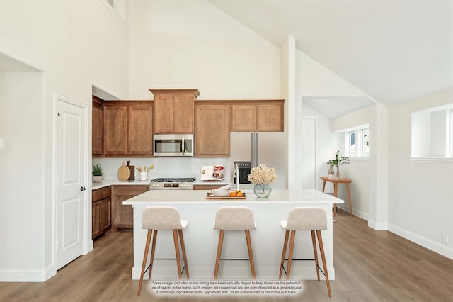 kitchen featuring a kitchen breakfast bar, stainless steel appliances, and a kitchen island with sink