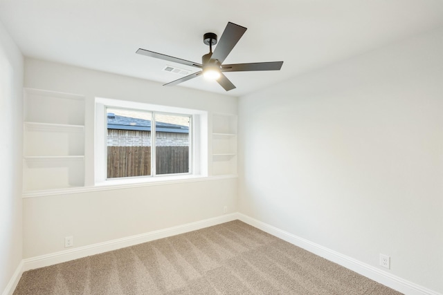 unfurnished room with carpet, ceiling fan, and built in shelves