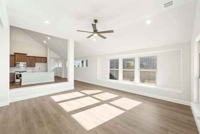 unfurnished living room featuring light hardwood / wood-style floors, high vaulted ceiling, ceiling fan, and sink