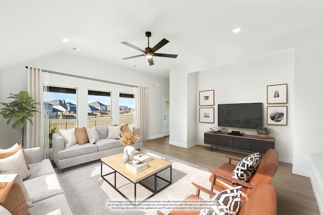 living room featuring hardwood / wood-style flooring, vaulted ceiling, and ceiling fan