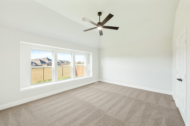 carpeted spare room featuring ceiling fan and vaulted ceiling