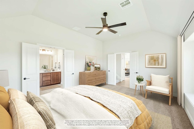 bedroom featuring ceiling fan, lofted ceiling, light carpet, and ensuite bath