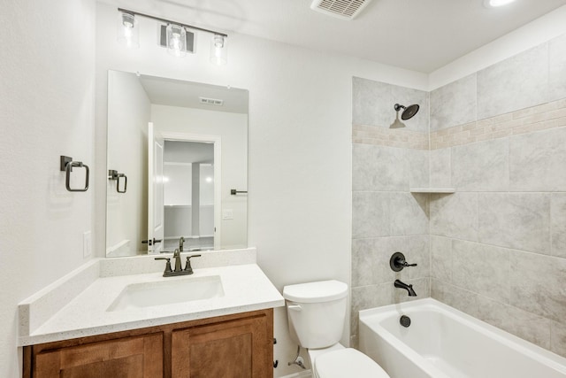 full bathroom featuring tiled shower / bath combo, toilet, and vanity