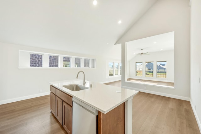 kitchen with a kitchen island with sink, sink, stainless steel dishwasher, and light hardwood / wood-style floors