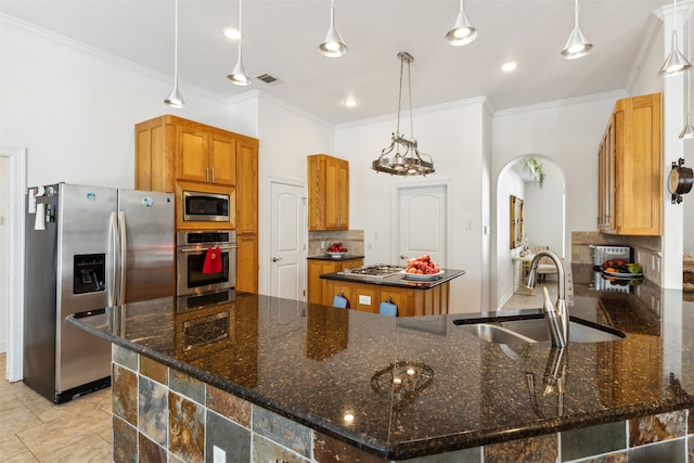 kitchen featuring a kitchen island, dark stone countertops, sink, and appliances with stainless steel finishes