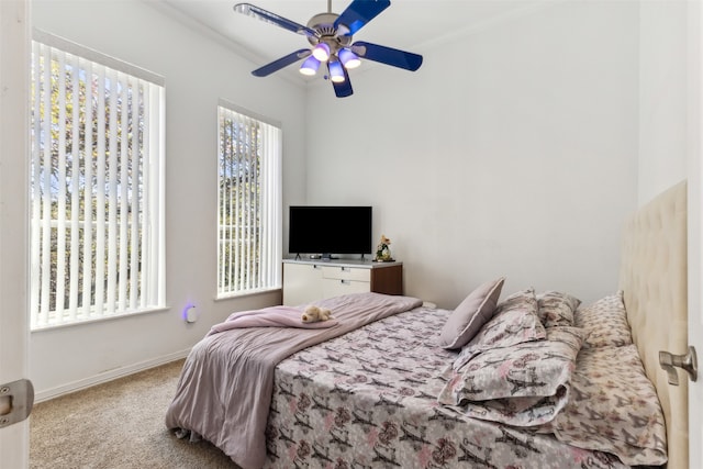 carpeted bedroom with ceiling fan and ornamental molding