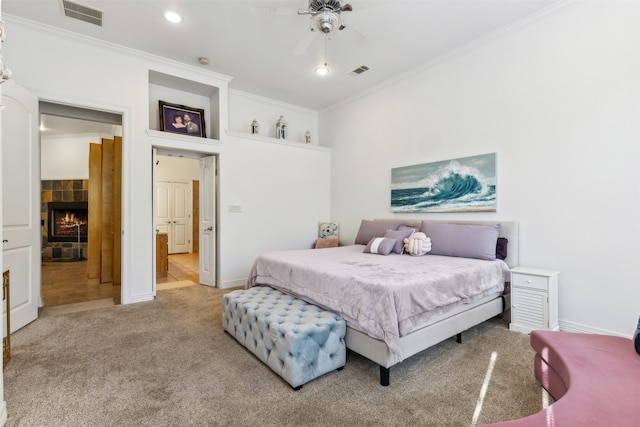 bedroom with carpet flooring, a fireplace, ceiling fan, and crown molding