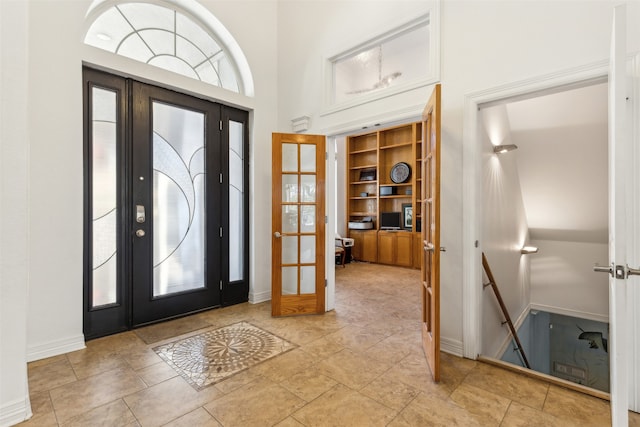 entryway with a towering ceiling and french doors