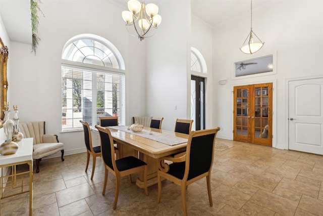 dining space featuring a chandelier, french doors, a towering ceiling, and a wealth of natural light