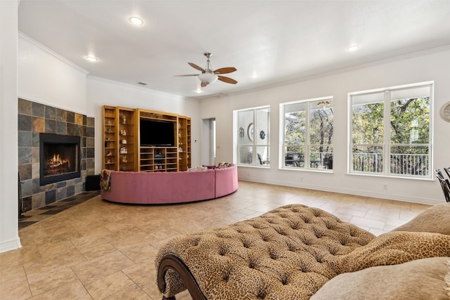 living room featuring ceiling fan, ornamental molding, and a fireplace