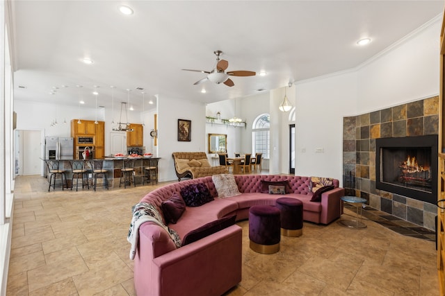 living room featuring a fireplace, ceiling fan, and crown molding