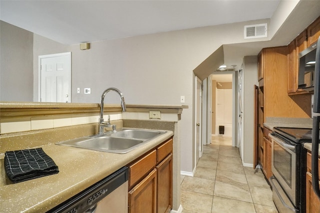 kitchen with visible vents, brown cabinetry, stainless steel appliances, light countertops, and a sink