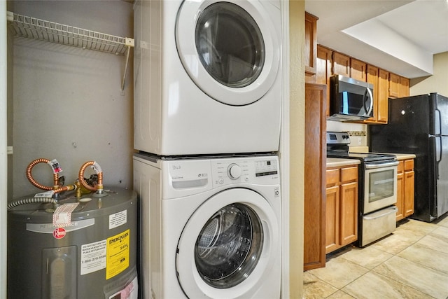 laundry area with laundry area, water heater, stacked washing maching and dryer, and light tile patterned flooring