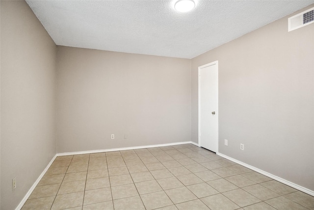 empty room featuring baseboards, visible vents, and a textured ceiling