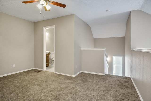 interior space with lofted ceiling, light carpet, a textured ceiling, and baseboards