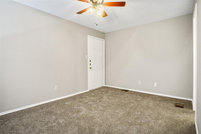 empty room with carpet floors, visible vents, a ceiling fan, a textured ceiling, and baseboards