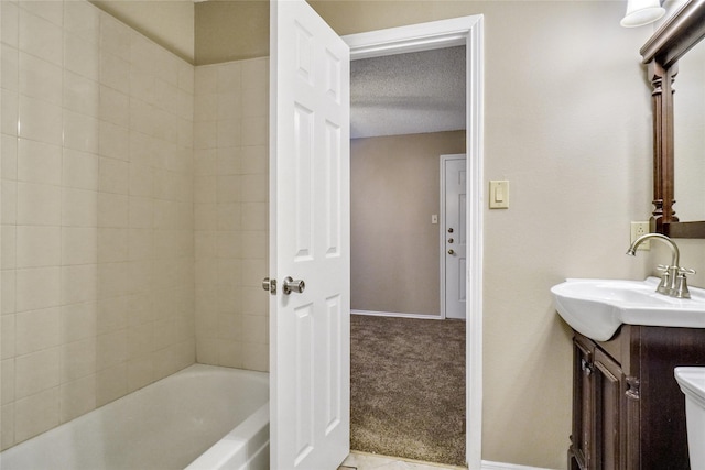 bathroom with toilet, baseboards, a textured ceiling, and vanity