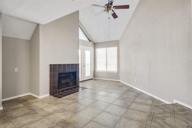 unfurnished living room featuring baseboards, a tiled fireplace, ceiling fan, tile patterned floors, and high vaulted ceiling