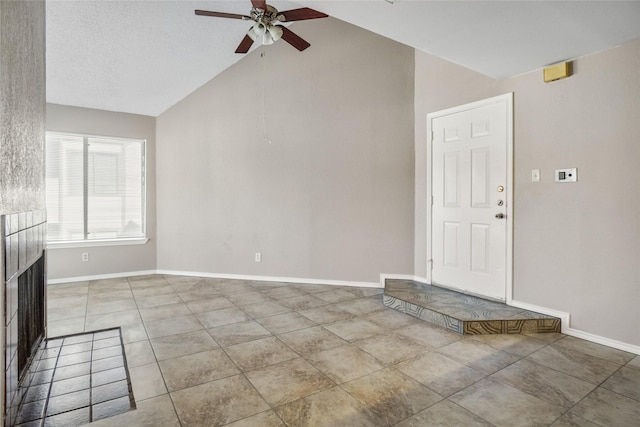 unfurnished living room featuring light tile patterned floors, baseboards, vaulted ceiling, and a ceiling fan