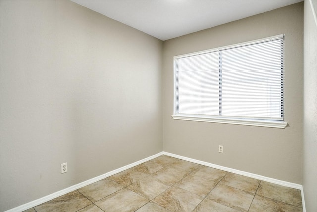 empty room featuring light tile patterned floors and baseboards