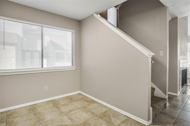 unfurnished room with tile patterned flooring, stairs, and baseboards