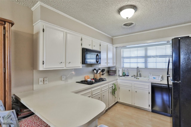 kitchen featuring sink, kitchen peninsula, white cabinets, and black appliances