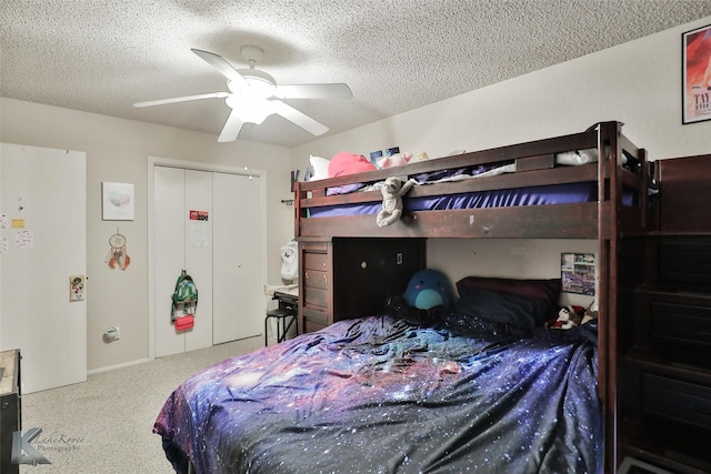 carpeted bedroom with ceiling fan and a textured ceiling