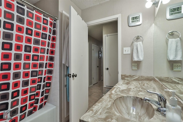 bathroom featuring tile patterned flooring, vanity, shower / tub combo with curtain, and a textured ceiling