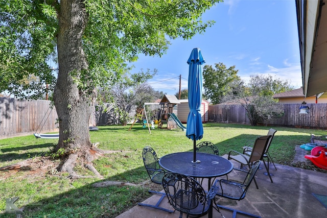 view of yard featuring a playground and a patio