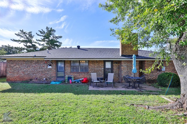 rear view of house featuring a lawn and a patio