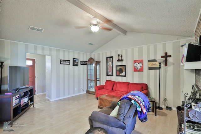 living room with vaulted ceiling with beams, light hardwood / wood-style floors, a textured ceiling, and ceiling fan