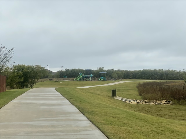 view of home's community featuring a playground and a lawn