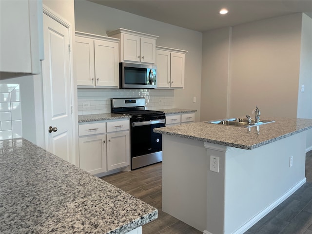 kitchen with sink, stainless steel appliances, dark hardwood / wood-style flooring, backsplash, and white cabinets